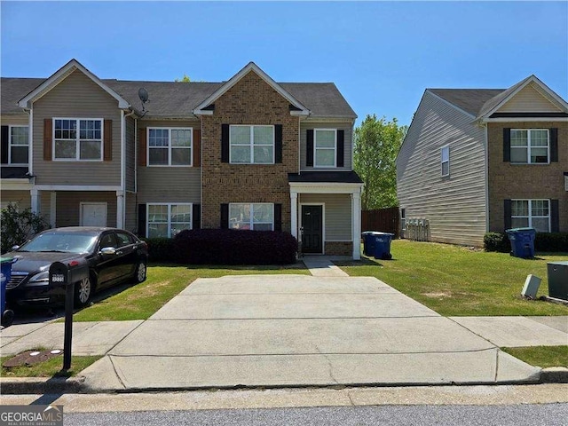 view of front of home with a front lawn and brick siding