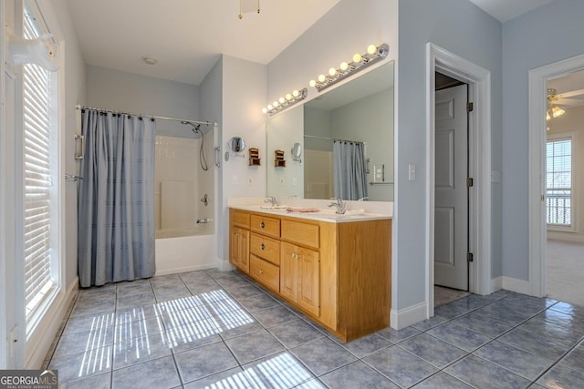 full bath featuring tile patterned floors, a sink, double vanity, baseboards, and ceiling fan
