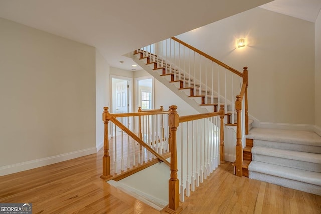 stairs with baseboards and wood finished floors