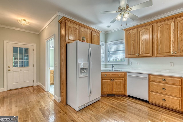 kitchen featuring stainless steel dishwasher, crown molding, a sink, and white refrigerator with ice dispenser