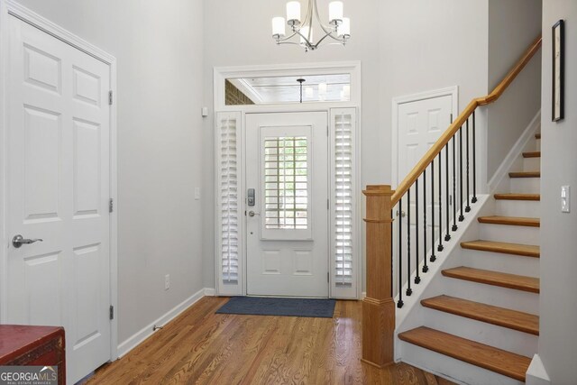 123 Heritage Pointe, Woodstock, GA 30189 - foyer with a chandelier, wood finished floors, stairway, and baseboards