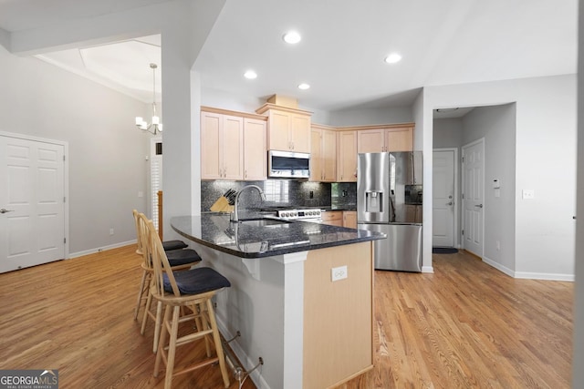 123 Heritage Pointe, Woodstock, GA 30189 - kitchen with stainless steel appliances, a sink, a breakfast bar area, a peninsula, and baseboards