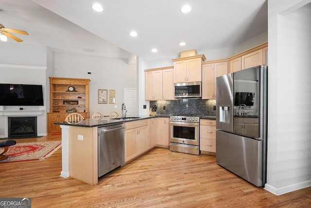 123 Heritage Pointe, Woodstock, GA 30189 - kitchen with appliances with stainless steel finishes, a peninsula, light brown cabinets, a sink, and light wood-style flooring