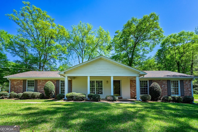view of front facade with brick siding and a front lawn