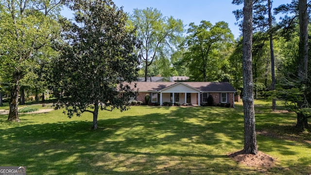 view of front of house featuring a front lawn, covered porch, and brick siding