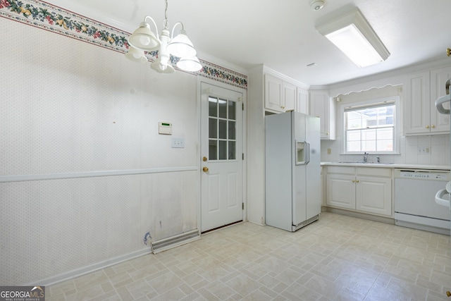 kitchen featuring white cabinets, a sink, a chandelier, white appliances, and light countertops