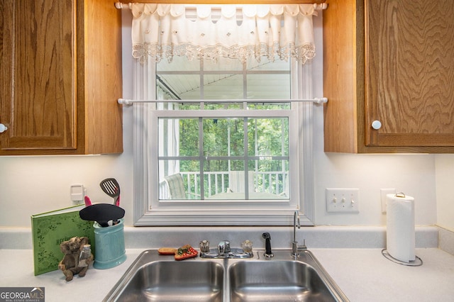 kitchen with a sink, brown cabinetry, and light countertops