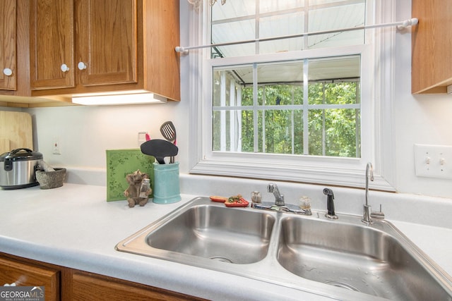 kitchen with a sink, brown cabinets, and light countertops