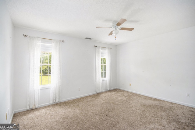 carpeted empty room with plenty of natural light, ceiling fan, and baseboards