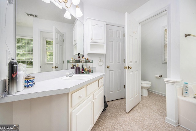 full bath featuring toilet, vanity, a garden tub, baseboards, and tile patterned floors