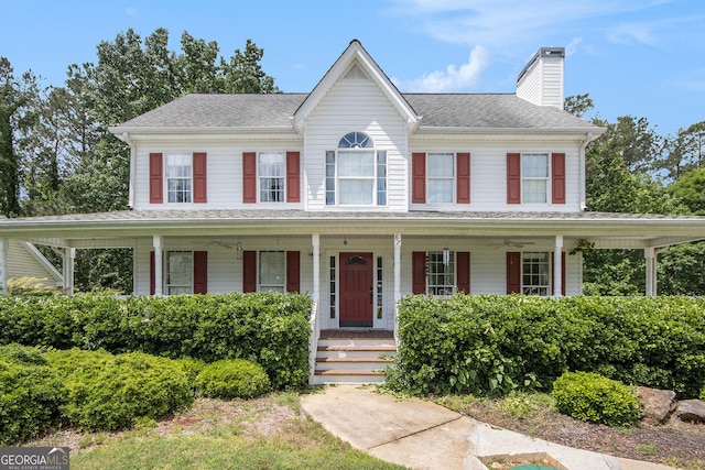 view of front of property featuring a porch, a chimney, roof with shingles, and a ceiling fan