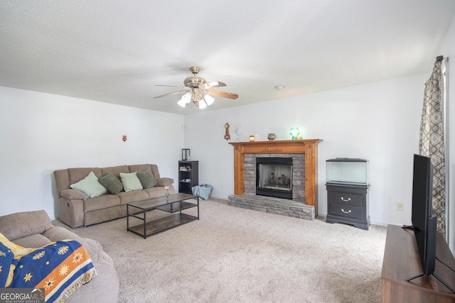 carpeted living room with a ceiling fan and a fireplace with raised hearth