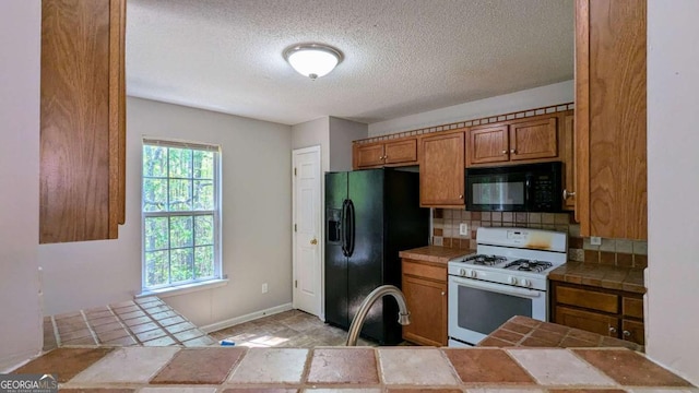366 Blue Springs Way, Dallas, GA 30157 - kitchen featuring a textured ceiling, backsplash, brown cabinetry, tile countertops, and black appliances