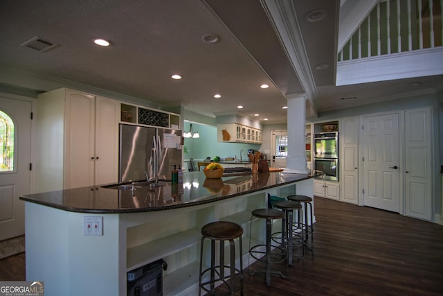 kitchen with stainless steel appliances, visible vents, ornate columns, open shelves, and ornamental molding