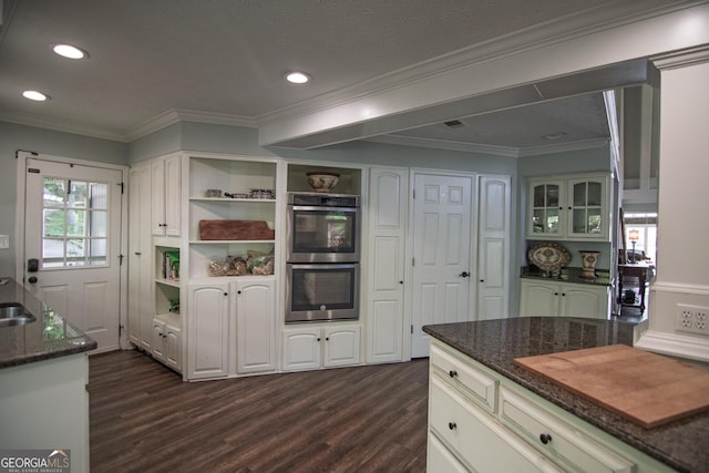 kitchen with open shelves, stainless steel double oven, dark stone countertops, and dark wood-style flooring