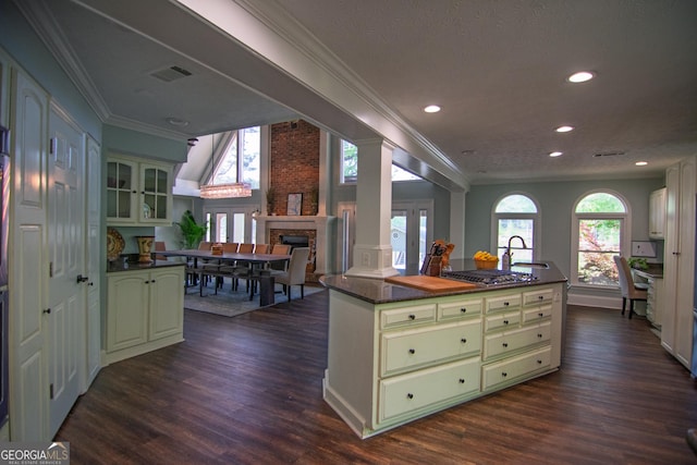 kitchen with dark countertops, a fireplace, and green cabinets