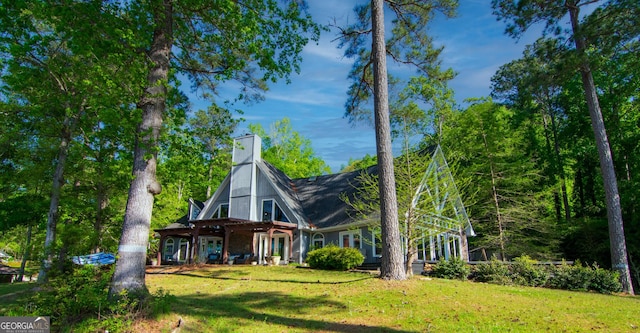 exterior space featuring a chimney, a front lawn, and covered porch