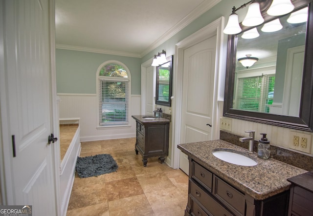 bathroom with two vanities, a wealth of natural light, a wainscoted wall, and a sink