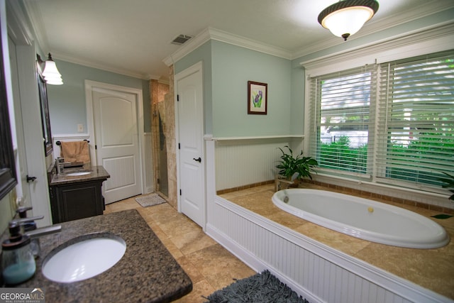 full bath with a garden tub, wainscoting, vanity, ornamental molding, and visible vents