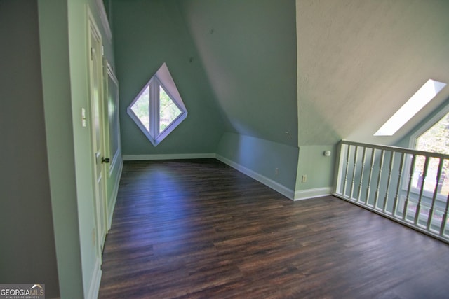 bonus room with baseboards, dark wood-style floors, and lofted ceiling with skylight