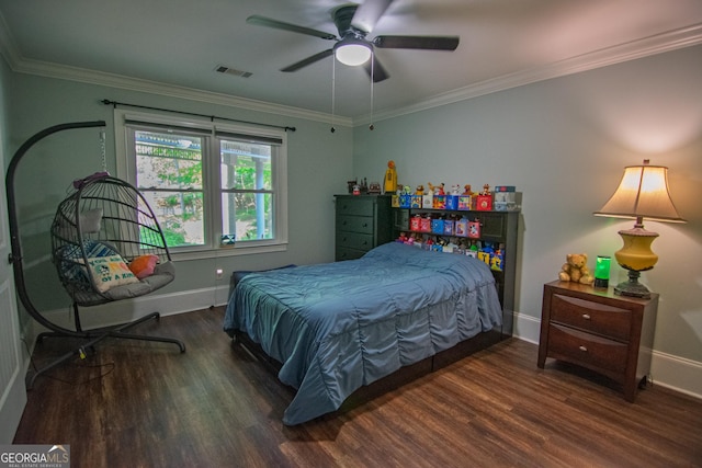 bedroom with baseboards, crown molding, wood finished floors, and visible vents