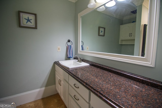 bathroom with baseboards, tile patterned flooring, vanity, and ornamental molding