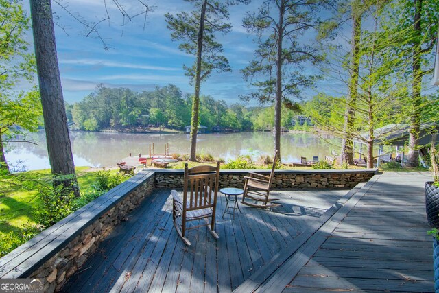 deck with a dock and a water view