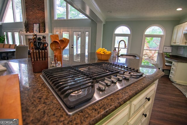 kitchen with stainless steel gas cooktop, ornamental molding, french doors, and a sink