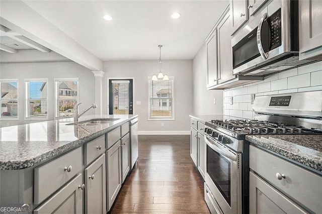 kitchen featuring a sink, gray cabinets, stainless steel appliances, backsplash, and baseboards
