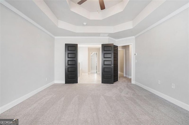 unfurnished bedroom with baseboards, carpet flooring, a raised ceiling, and ceiling fan