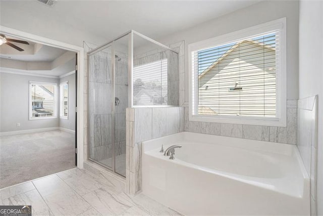 bathroom with a shower stall, ceiling fan, a healthy amount of sunlight, and a bath