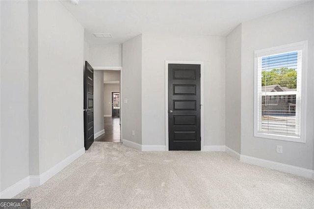 unfurnished bedroom featuring carpet floors and baseboards
