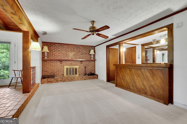 unfurnished living room with a ceiling fan, brick wall, carpet, ornamental molding, and a textured ceiling