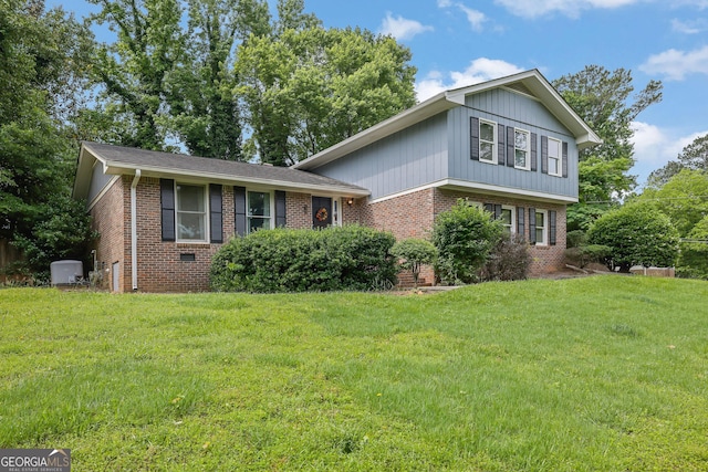 tri-level home featuring brick siding and a front lawn