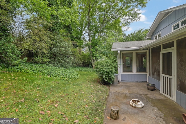 view of grassy yard with a patio and a sunroom