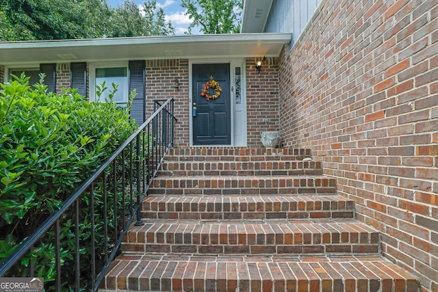 entrance to property featuring brick siding