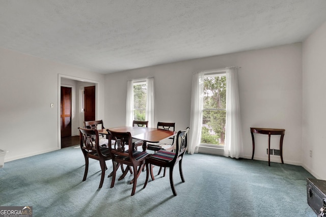 dining space featuring carpet flooring, a textured ceiling, and baseboards