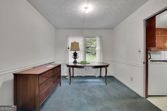 carpeted office featuring a textured ceiling and baseboards