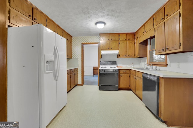 kitchen with white refrigerator with ice dispenser, range with gas cooktop, under cabinet range hood, dishwasher, and a sink