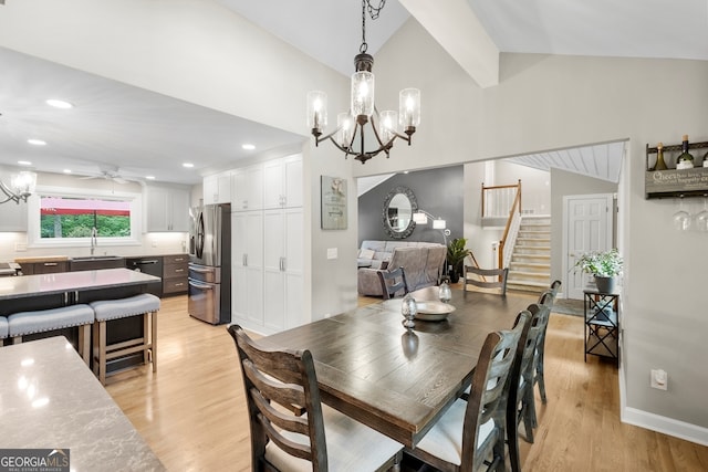 dining room featuring stairway, light wood-style flooring, lofted ceiling, and ceiling fan with notable chandelier