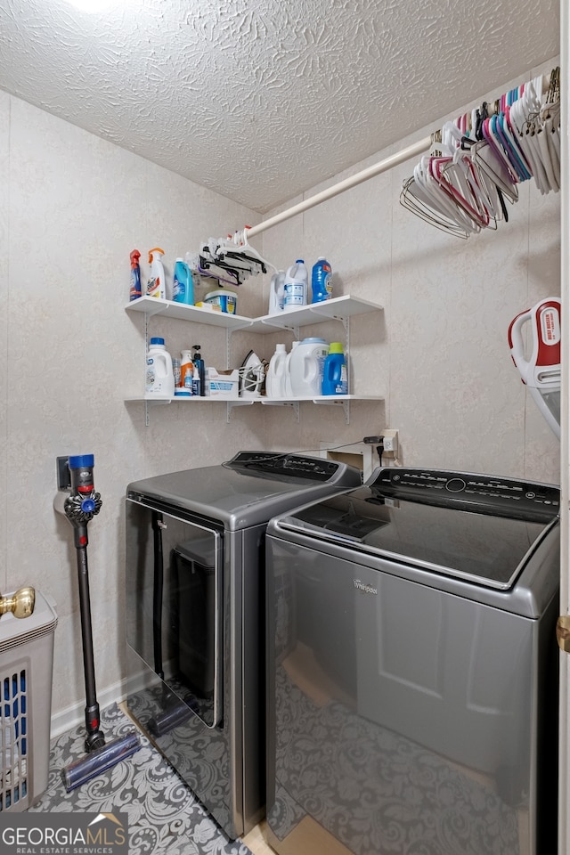 washroom with washer and dryer, a textured ceiling, and laundry area