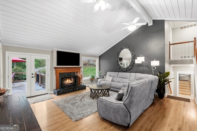 living area with lofted ceiling with beams, a ceiling fan, wood finished floors, and a healthy amount of sunlight