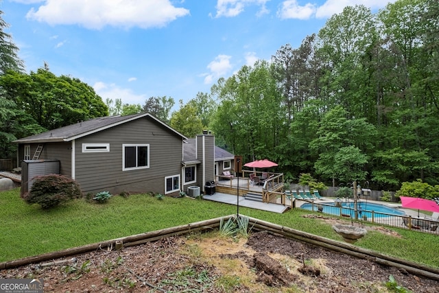back of house with fence, cooling unit, a yard, and a fenced in pool