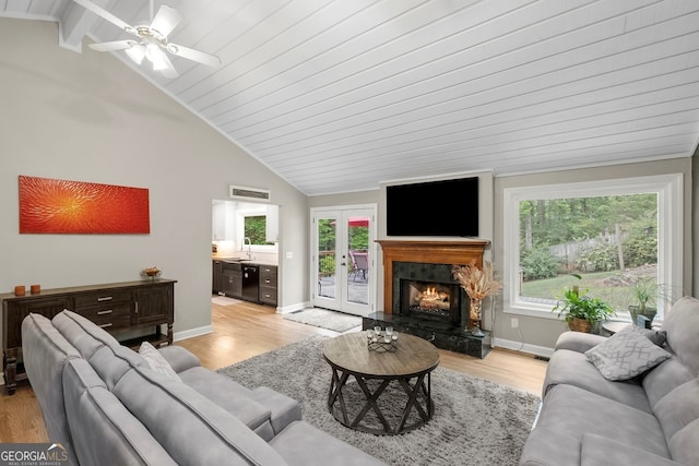 living room featuring visible vents, light wood finished floors, and plenty of natural light