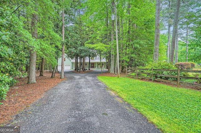 view of home's community with fence, driveway, and a garage