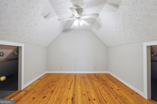 additional living space with a textured ceiling, ceiling fan, hardwood / wood-style floors, and baseboards