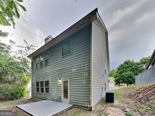 1162 Ida Woods Ln Unit 23, Lawrenceville, GA 30045 - rear view of house featuring central AC and a chimney