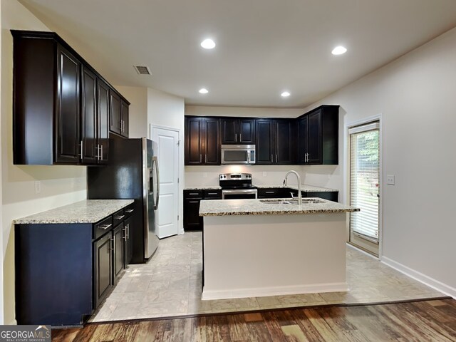 1162 Ida Woods Ln Unit 23, Lawrenceville, GA 30045 - kitchen featuring appliances with stainless steel finishes, a sink, light stone countertops, a kitchen island with sink, and recessed lighting