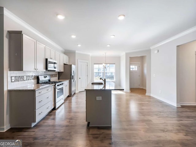 2959 Rambler Dr, Loganville, GA 30052 - kitchen with a kitchen island with sink, baseboards, decorative backsplash, appliances with stainless steel finishes, and ornamental molding