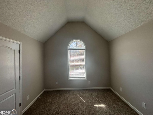 1365 Jubilee Ln, Mcdonough, GA 30253 - unfurnished room with dark colored carpet, a textured ceiling, lofted ceiling, and baseboards
